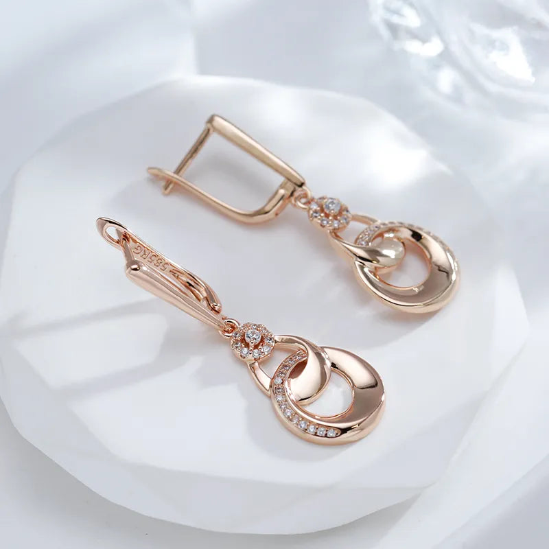 Boucles d'oreilles pendantes anneaux enlacés, bijou en plaqué or rose et en zircons naturels