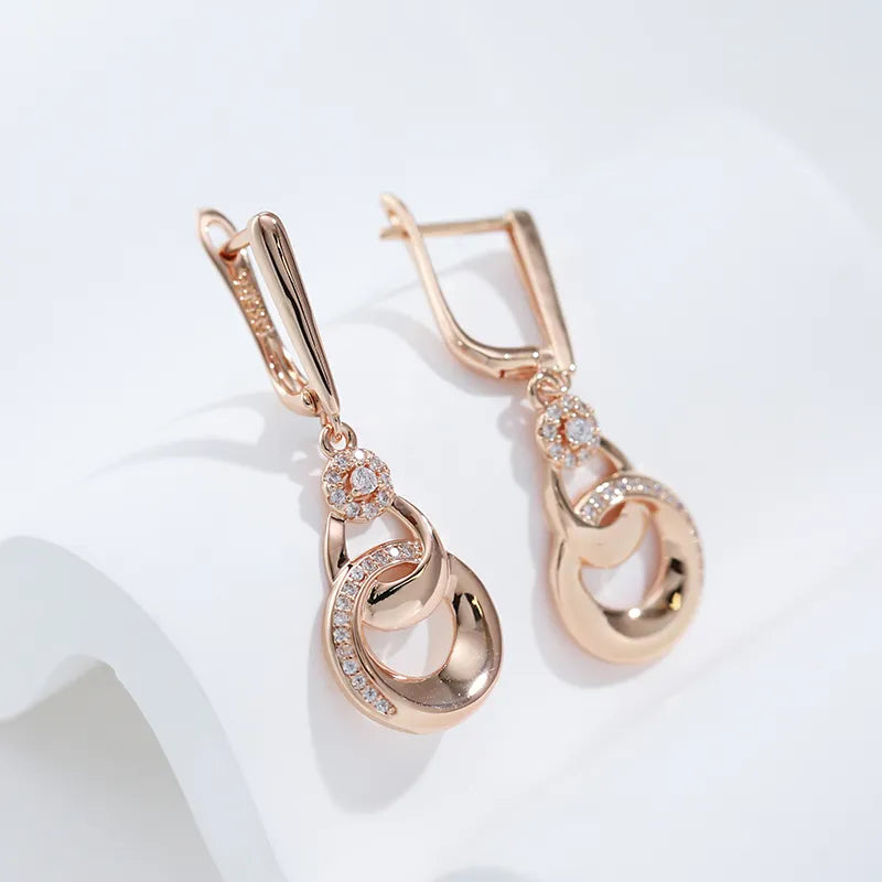 Boucles d'oreilles pendantes anneaux enlacés, bijou en plaqué or rose et en zircons naturels